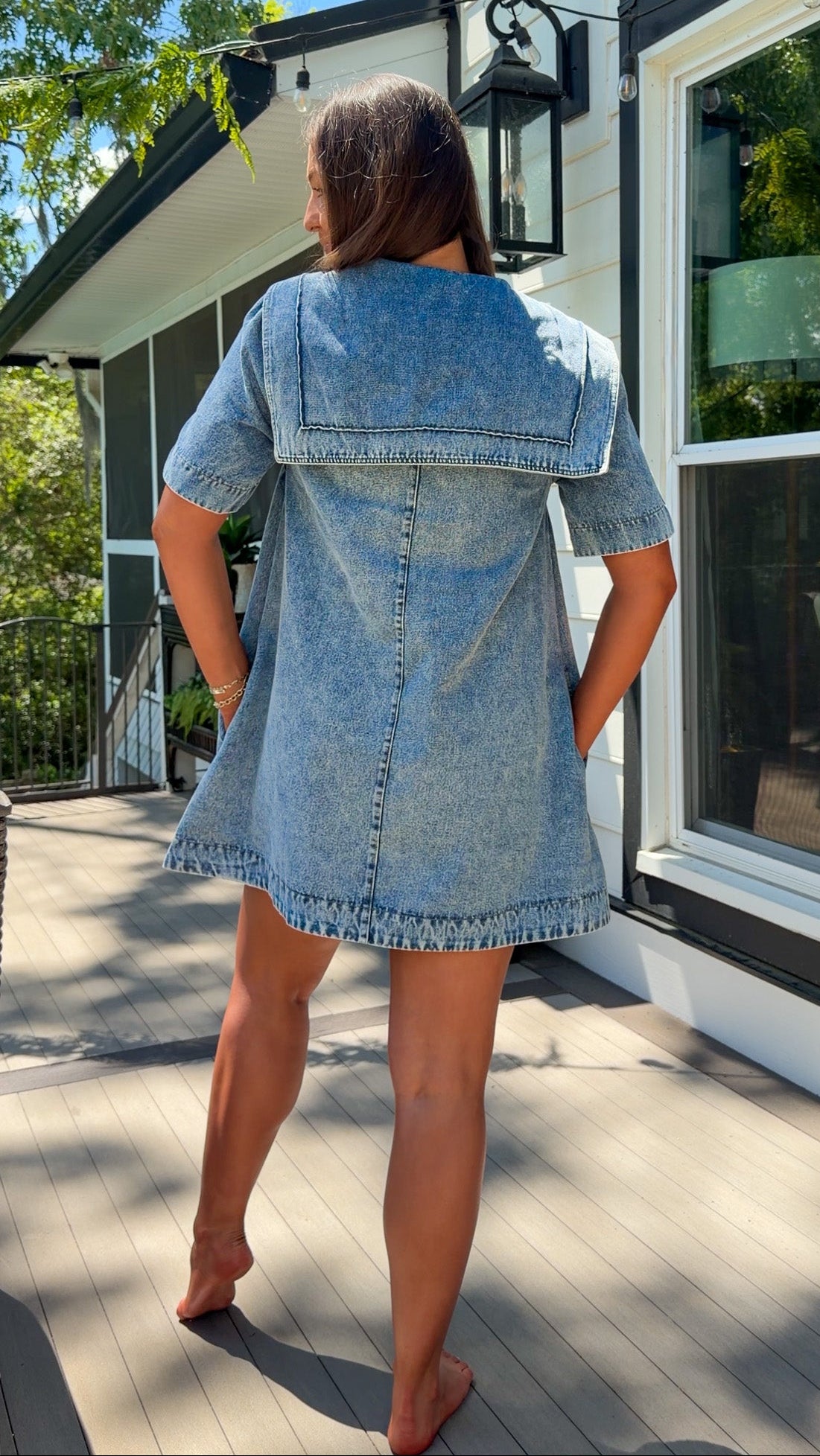 light wash denim mini dress with oversized collar, tie front detail, short sleeves, and slightly oversized fit