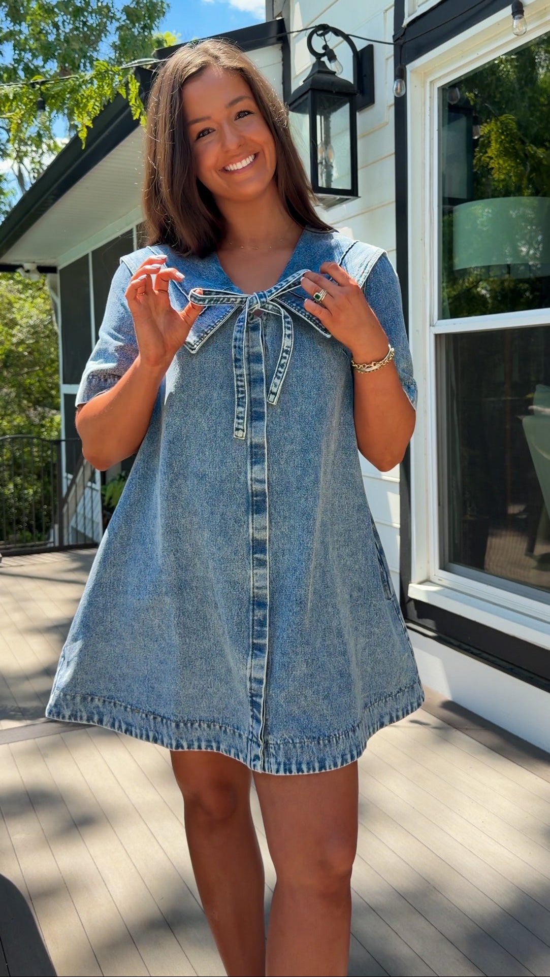 light wash denim mini dress with oversized collar, tie front detail, short sleeves, and slightly oversized fit
