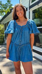 Denim romper with butterfly sleeves, tie neckline, and drawstring waist in blue