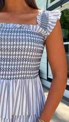 white and navy striped midi dress with smocked bodice, ruffle straps, and tiered skirt
