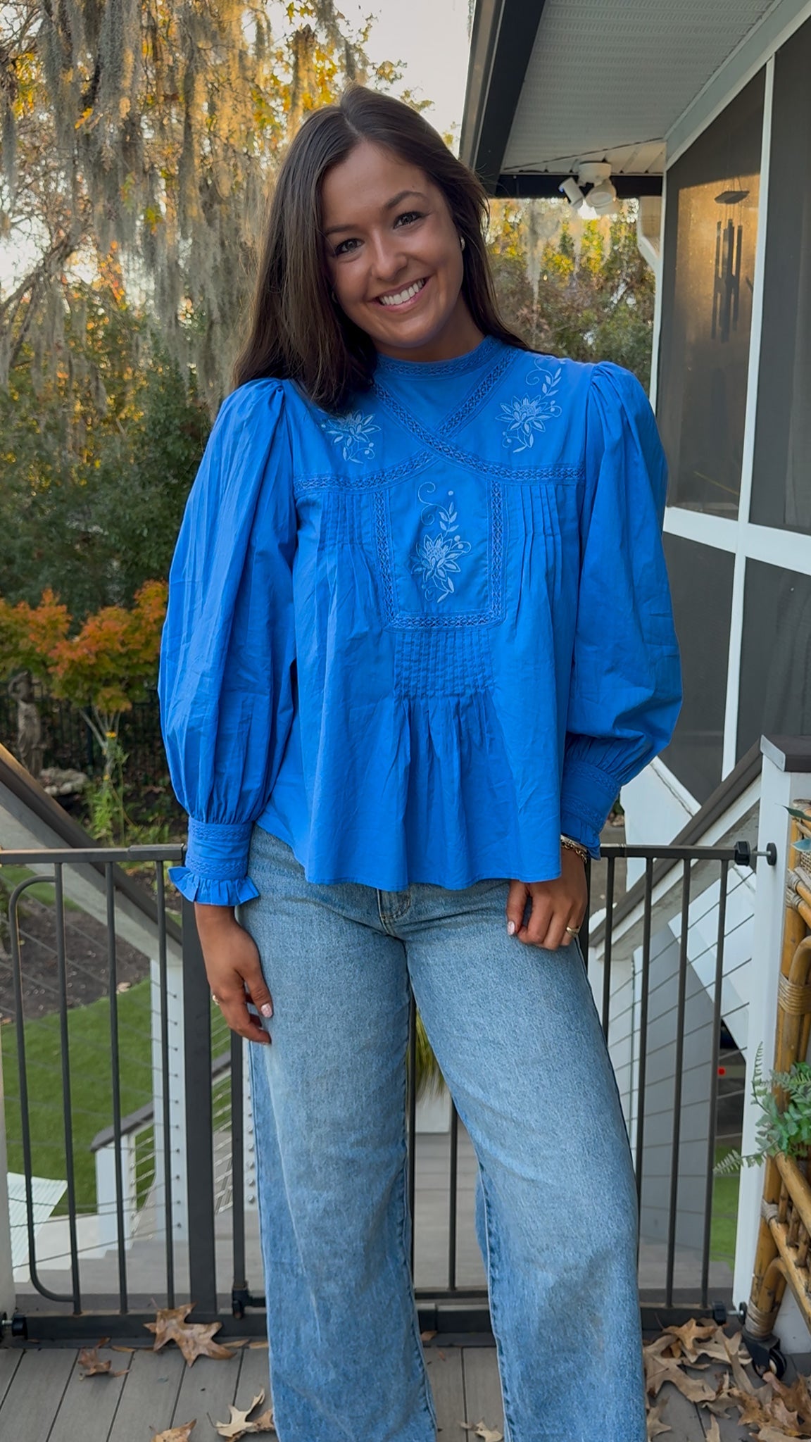 Azure blue embroidered blouse with puff sleeves and relaxed fit.