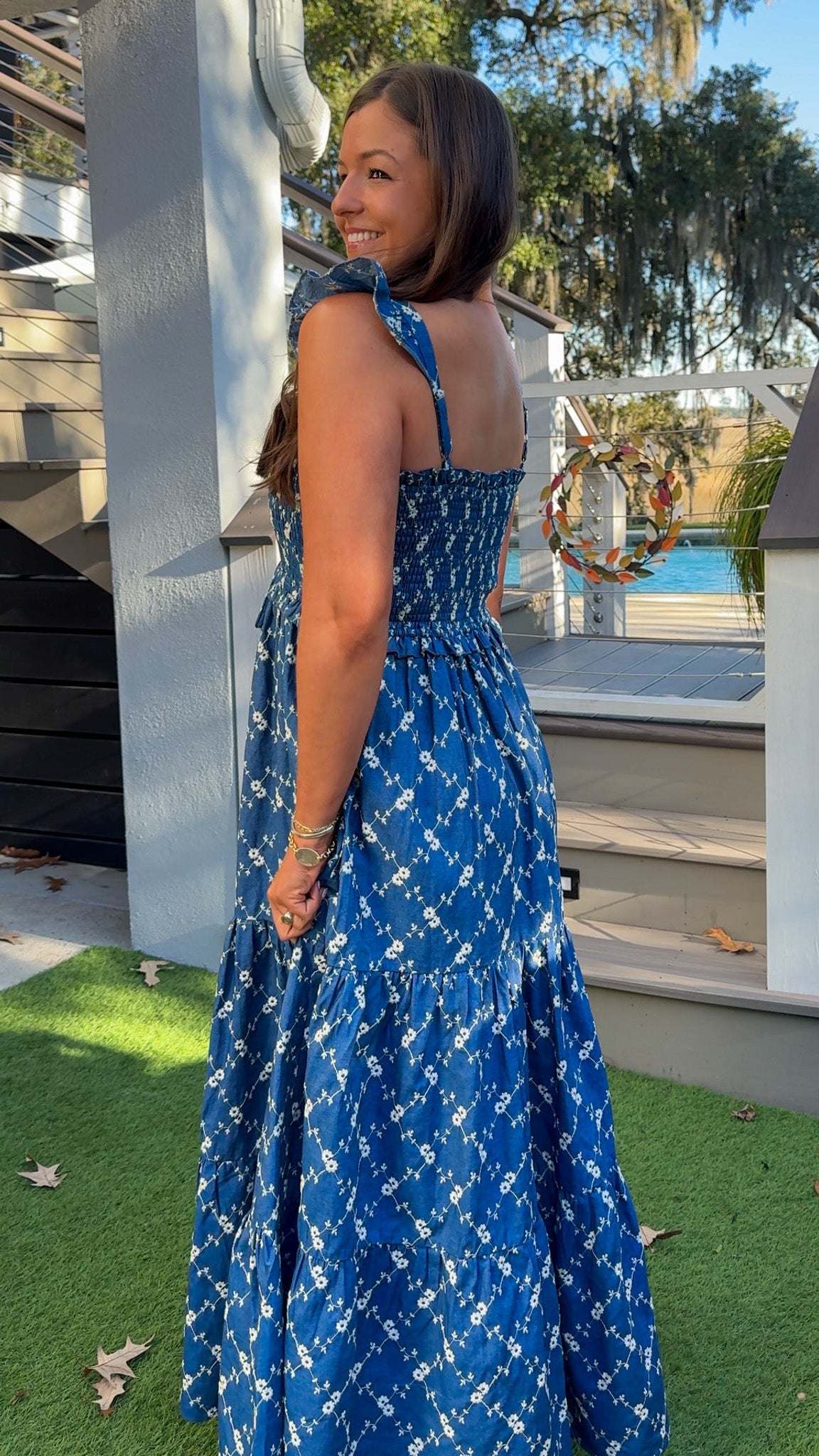 Denim blue and off-white floral tiered maxi dress with smocked bodice and flutter straps.