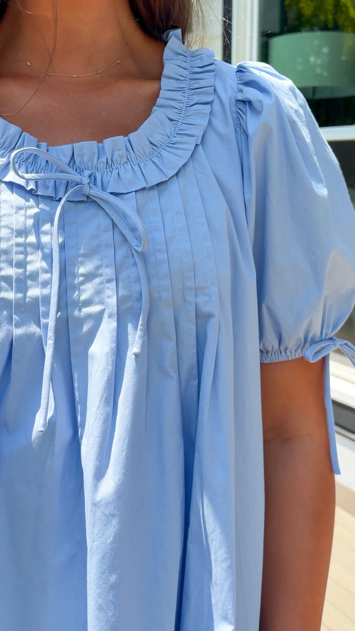 Light blue dresswith ruffled collar worn by a person.
