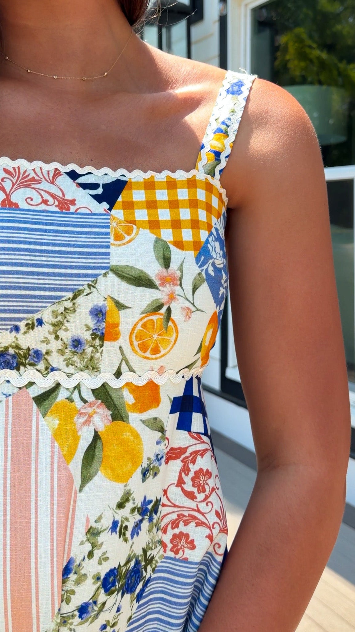 Close-up of a colorful patterned dress with floral and citrus designs.