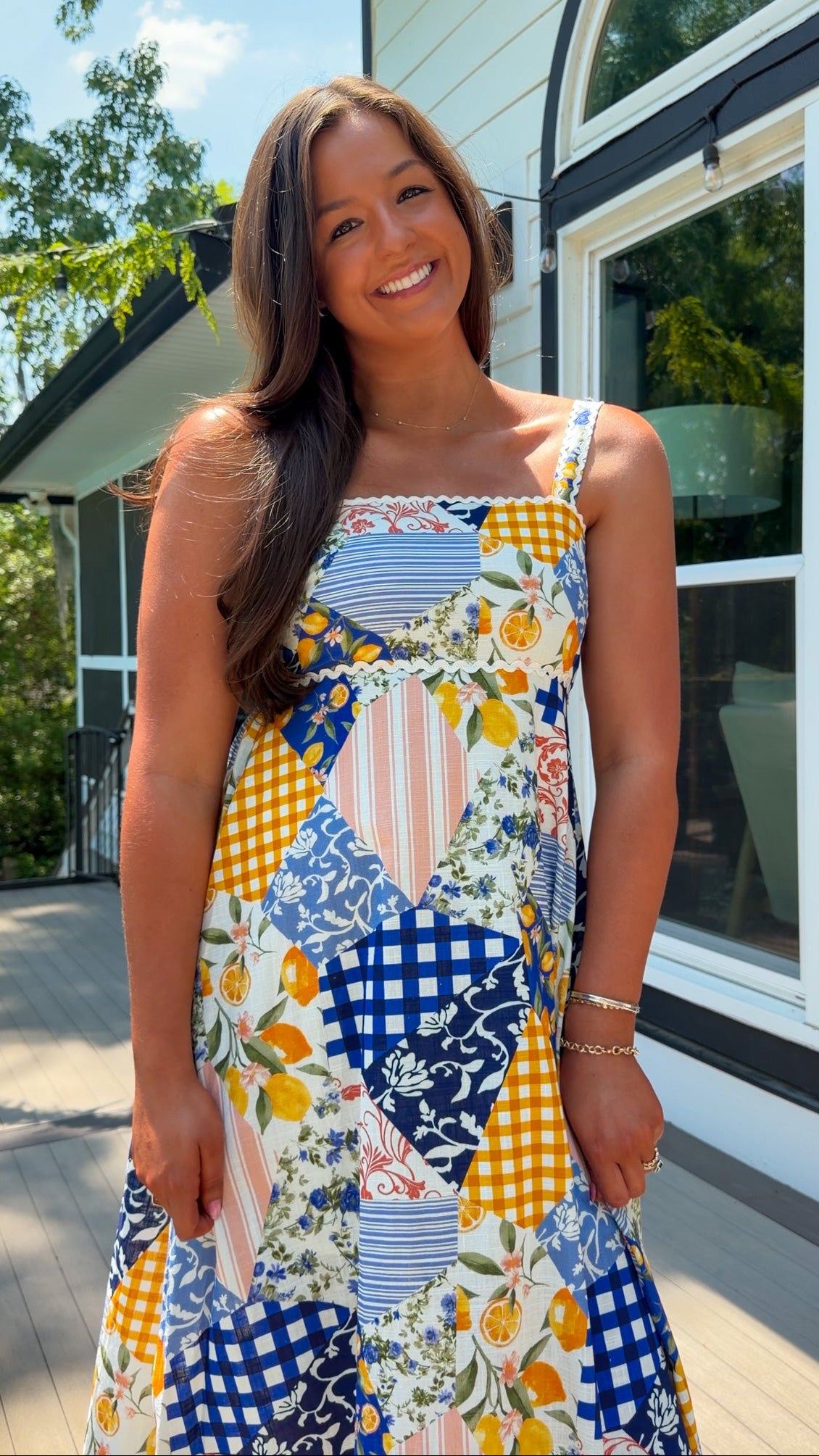 Woman wearing a colorful patterned dress standing outdoors.