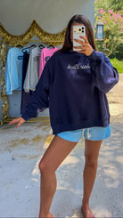 navy crewneck sweatshirt with white script "annie finch" embroidery 