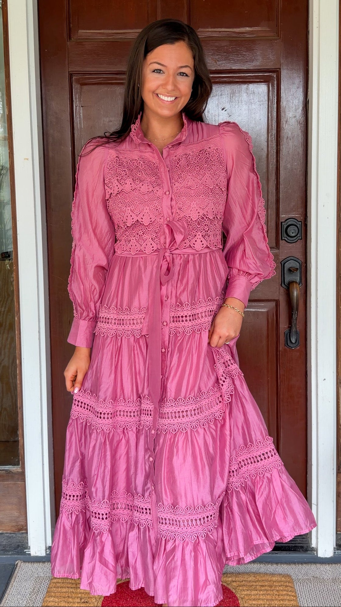 a satin midi dress with crochet lace panels, button-down front, long sleeves, and a self-tie waist in a soft plum color. pink mauve high neck 