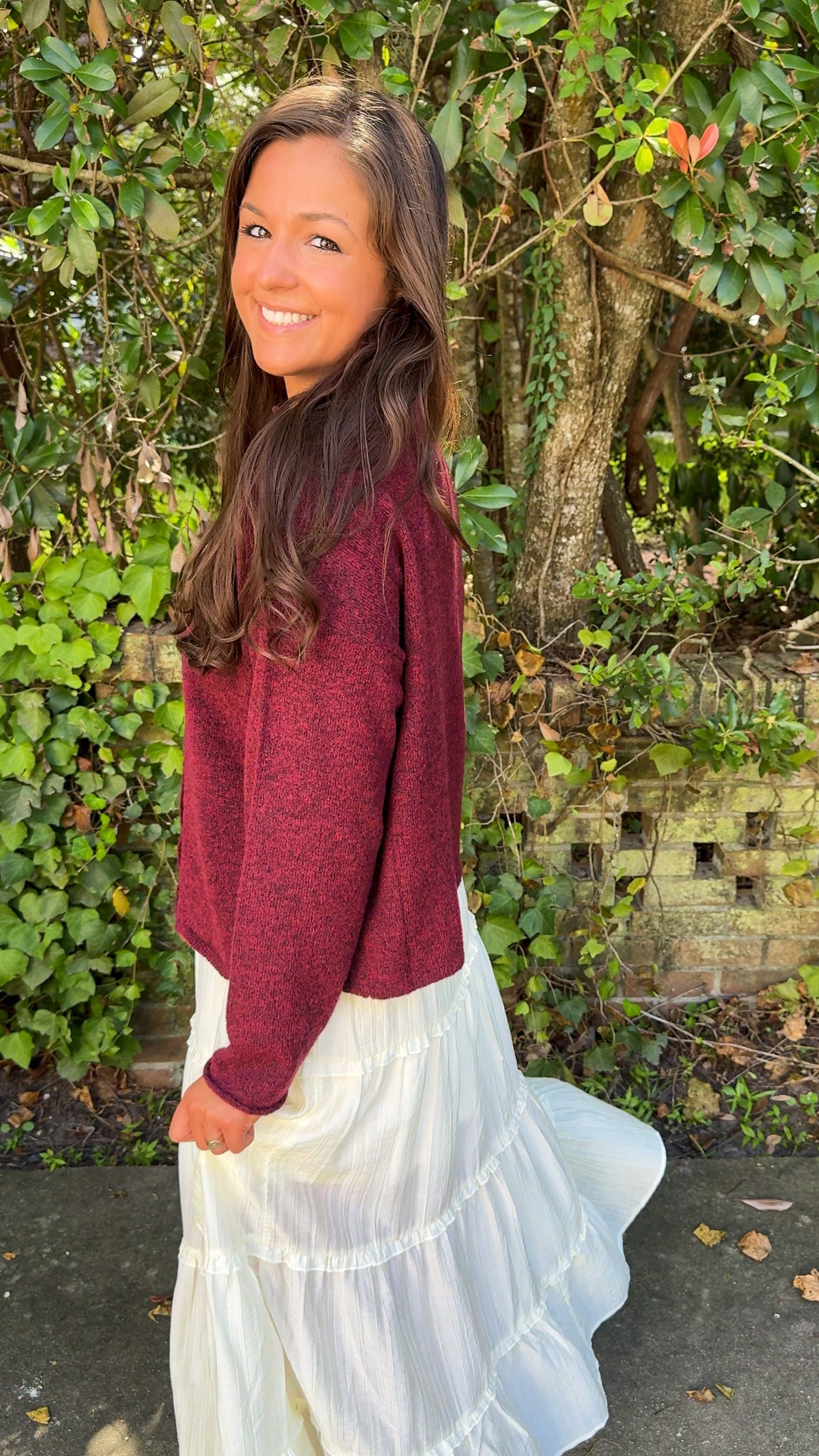 side view of burgundy maroon cardigan and white flowy midi skirt 