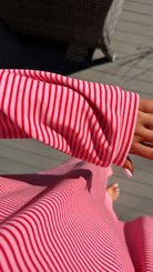 Close-up of a person wearing a red and white striped shirt with a blurred background