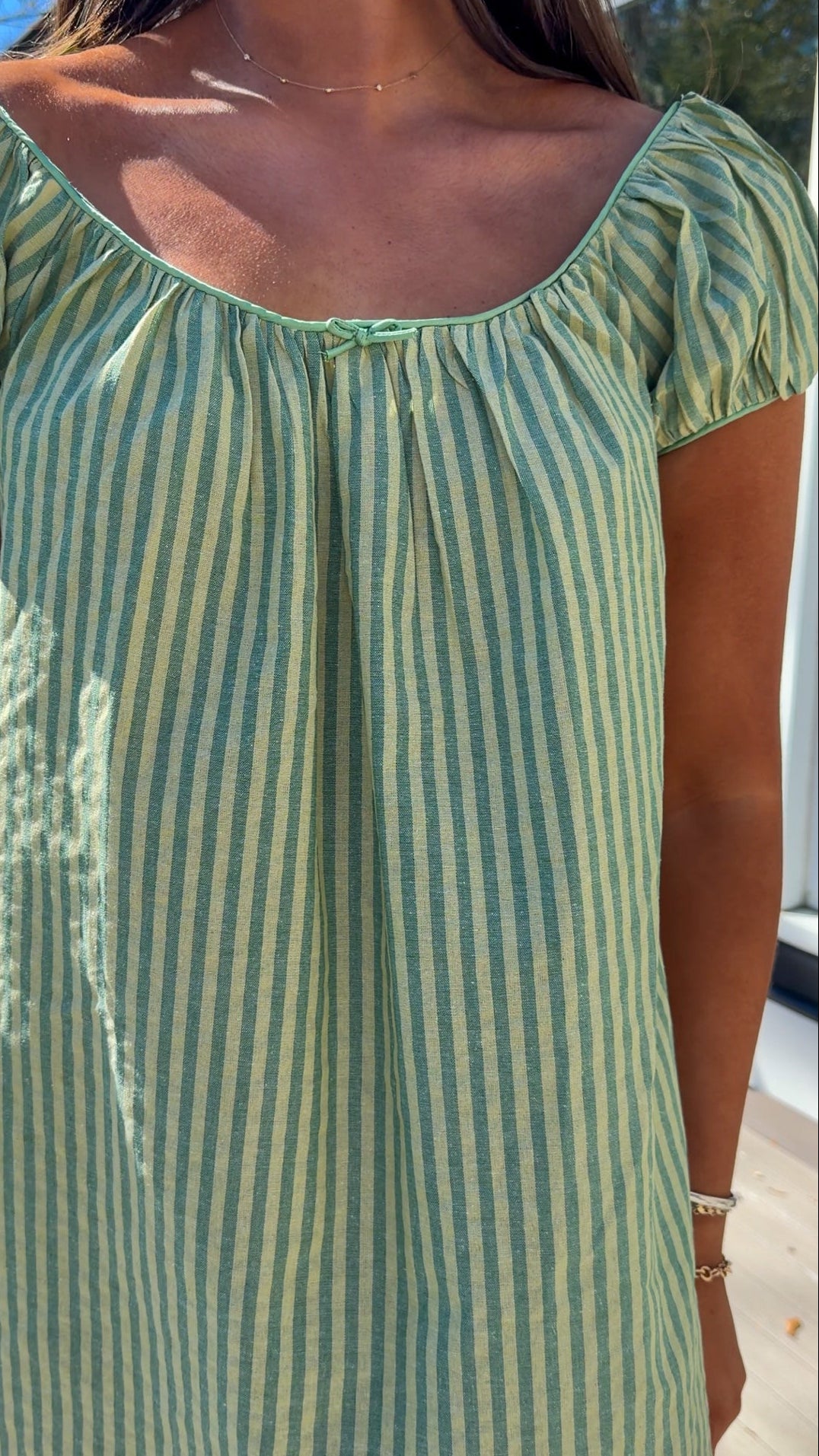 green striped babydoll mini dress with gathered neckline and pockets