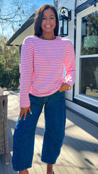pink and white striped long sleeve knit top with relaxed fit