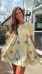 yellow mini dress with multicolor floral embroidery, ruffle collar, puff sleeves, and scalloped hem