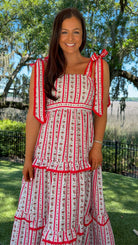 Woman wearing a red and white dress with a scenic background