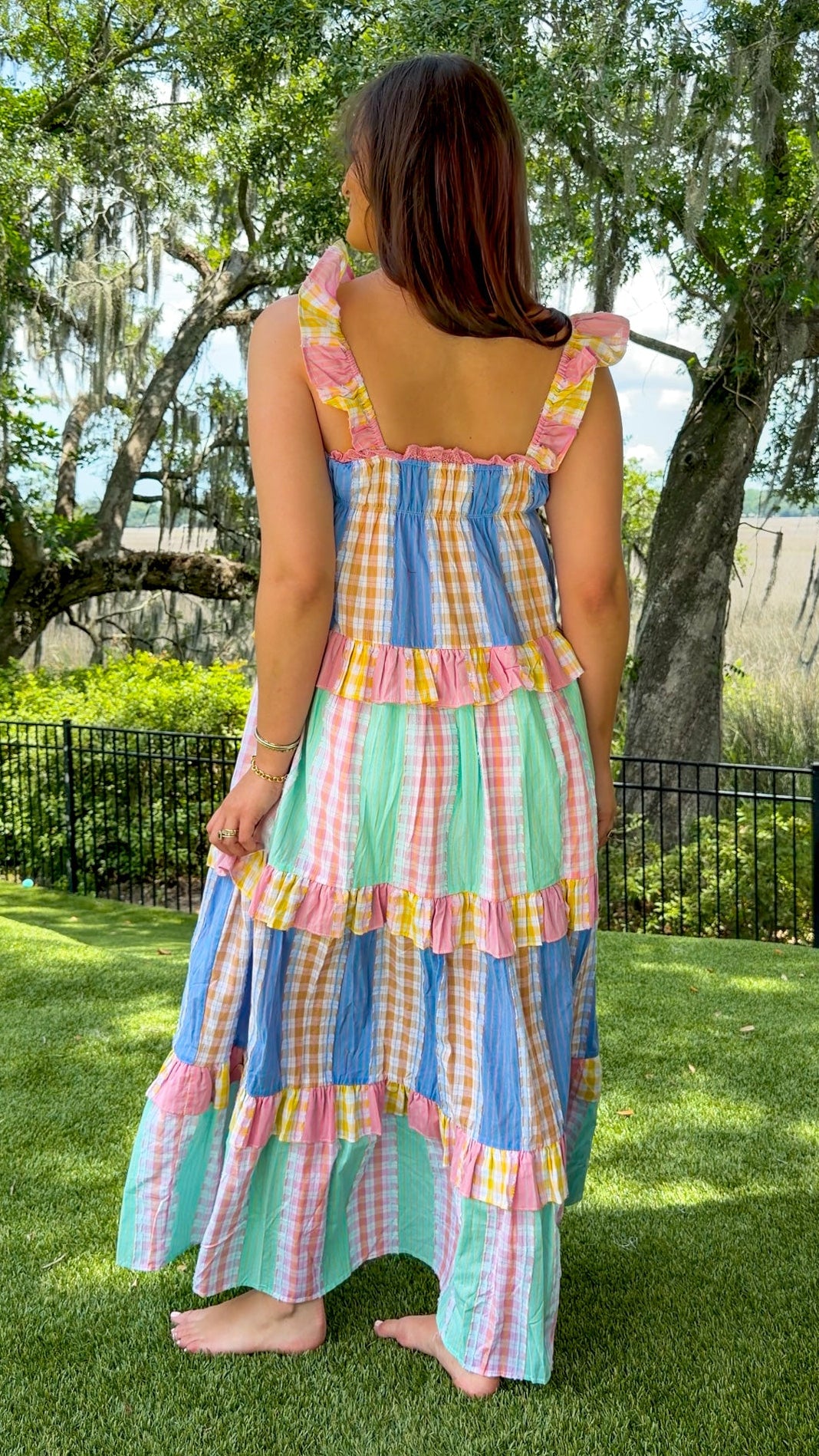 Pastel patchwork maxi dress featuring mixed check and stripe prints in pink, blue, yellow, and mint with ruffle straps, heart-shaped front pockets, lace trim, and a relaxed flowy silhouette.