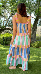 Pastel patchwork maxi dress featuring mixed check and stripe prints in pink, blue, yellow, and mint with ruffle straps, heart-shaped front pockets, lace trim, and a relaxed flowy silhouette.