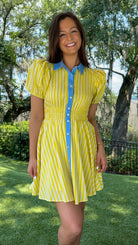 Yellow and ivory striped mini dress featuring a contrast blue collar and button placket, short puff sleeves, a smocked waist, side pockets, and a lightweight lined silhouette.