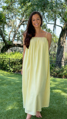 Butter yellow pinstripe maxi dress featuring adjustable spaghetti straps, a gathered square neckline, and a relaxed flowy silhouette in a lightweight woven fabric.