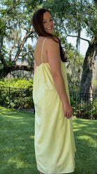 Butter yellow pinstripe maxi dress featuring adjustable spaghetti straps, a gathered square neckline, and a relaxed flowy silhouette in a lightweight woven fabric.
