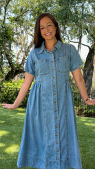Light wash chambray midi dress featuring a collared neckline, functional button-front closure, oversized chest pockets, short sleeves, side pockets, and a relaxed silhouette.