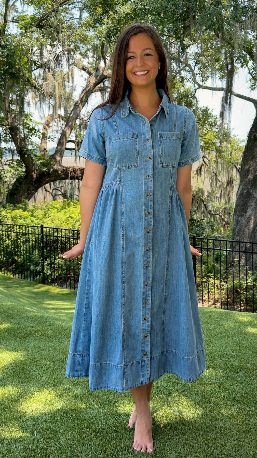 Light wash chambray midi dress featuring a collared neckline, functional button-front closure, oversized chest pockets, short sleeves, side pockets, and a relaxed silhouette.