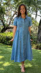 Light wash chambray midi dress featuring a collared neckline, functional button-front closure, oversized chest pockets, short sleeves, side pockets, and a relaxed silhouette.