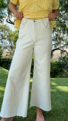 White high-rise wide leg denim jeans featuring contrast stitching, a cropped raw hem, front and back pockets, and a flattering structured fit.