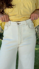White high-rise wide leg denim jeans featuring contrast stitching, a cropped raw hem, front and back pockets, and a flattering structured fit.