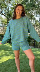 Olive and blue striped lounge set featuring a relaxed fit long sleeve crewneck top and matching elastic waist shorts with side pockets in a soft stretch knit fabric.