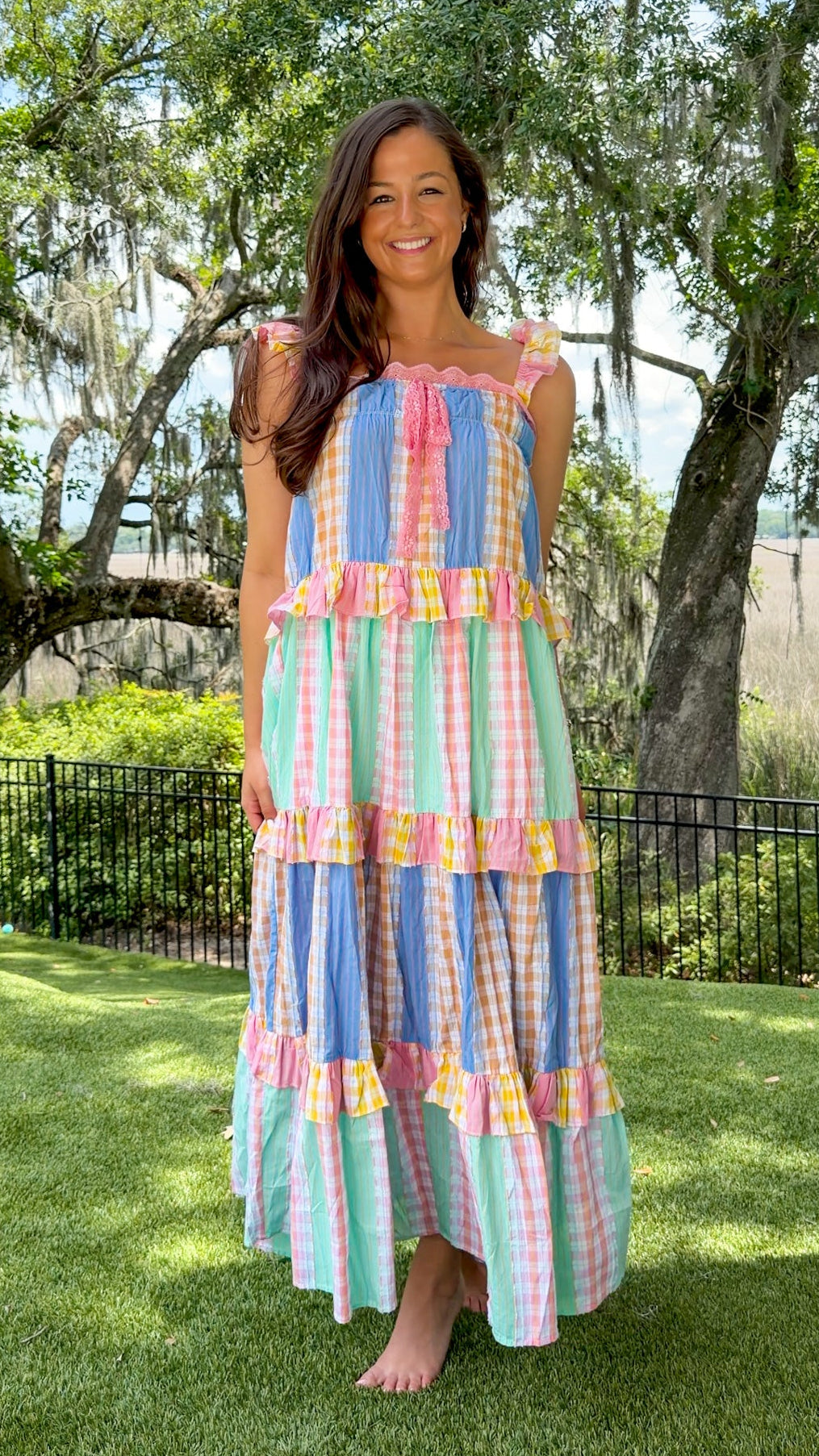 Pastel patchwork maxi dress featuring mixed check and stripe prints in pink, blue, yellow, and mint with ruffle straps, heart-shaped front pockets, lace trim, and a relaxed flowy silhouette.