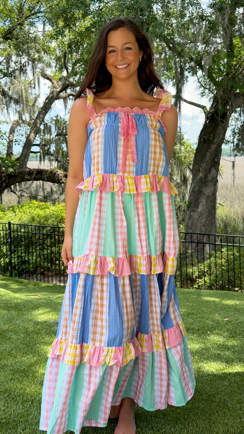 Pastel patchwork maxi dress featuring mixed check and stripe prints in pink, blue, yellow, and mint with ruffle straps, heart-shaped front pockets, lace trim, and a relaxed flowy silhouette.