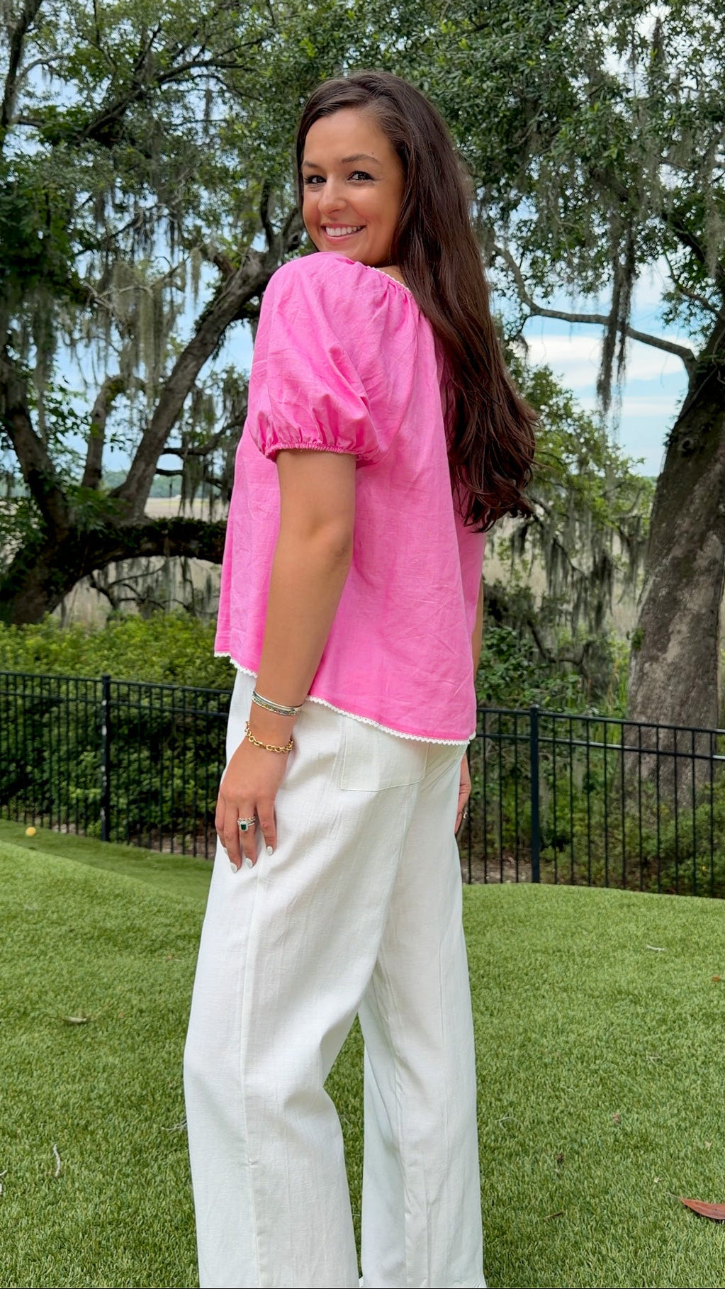 White full-length straight-leg pants featuring an elastic drawstring waistband, side and back patch pockets, delicate ruffle trim at the hem, and a relaxed, lightweight fit.
