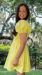 Yellow and ivory striped mini dress featuring a contrast blue collar and button placket, short puff sleeves, a smocked waist, side pockets, and a lightweight lined silhouette.