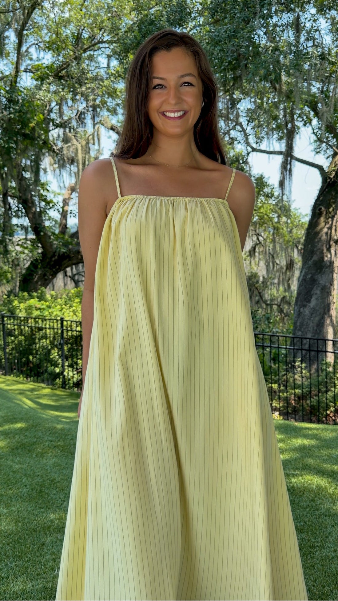 Butter yellow pinstripe maxi dress featuring adjustable spaghetti straps, a gathered square neckline, and a relaxed flowy silhouette in a lightweight woven fabric.