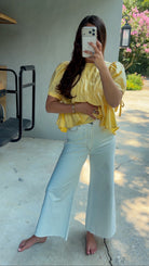 White high-rise wide leg denim jeans featuring contrast stitching, a cropped raw hem, front and back pockets, and a flattering structured fit.