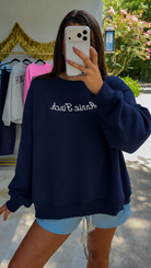 navy crewneck with white "annie finch" script embroidered on front